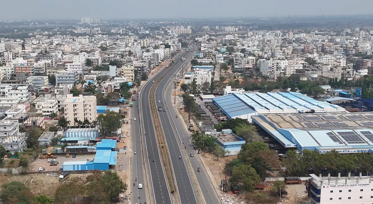 Aerial view of HMDA approved plotted layout near NH-65 Sangareddy showing built homes and road infrastructure in 2026